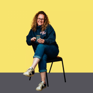 Woman sitting on chair with phone in hand with yellow background