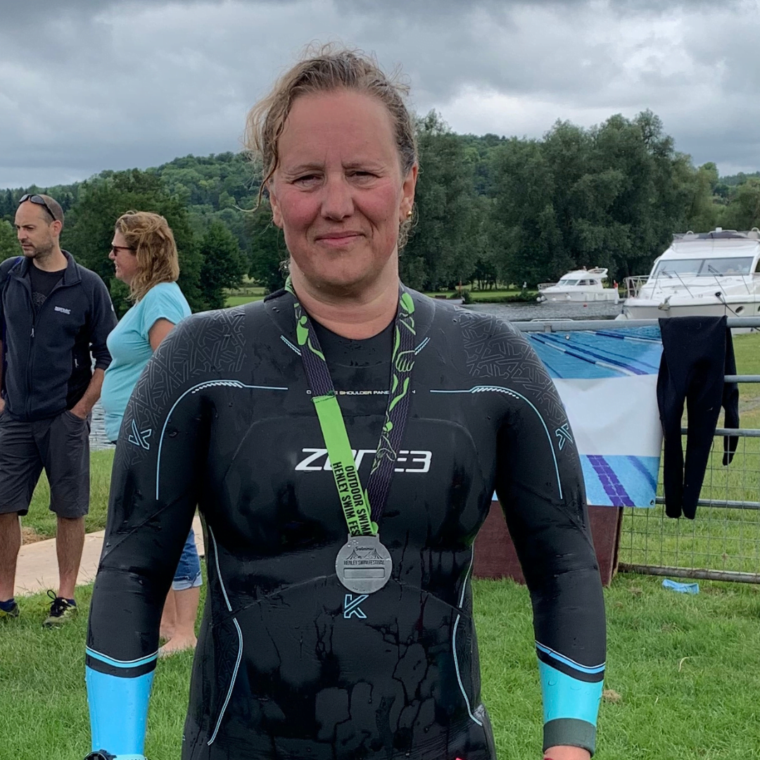 Woman in wet suit winning swimming race
